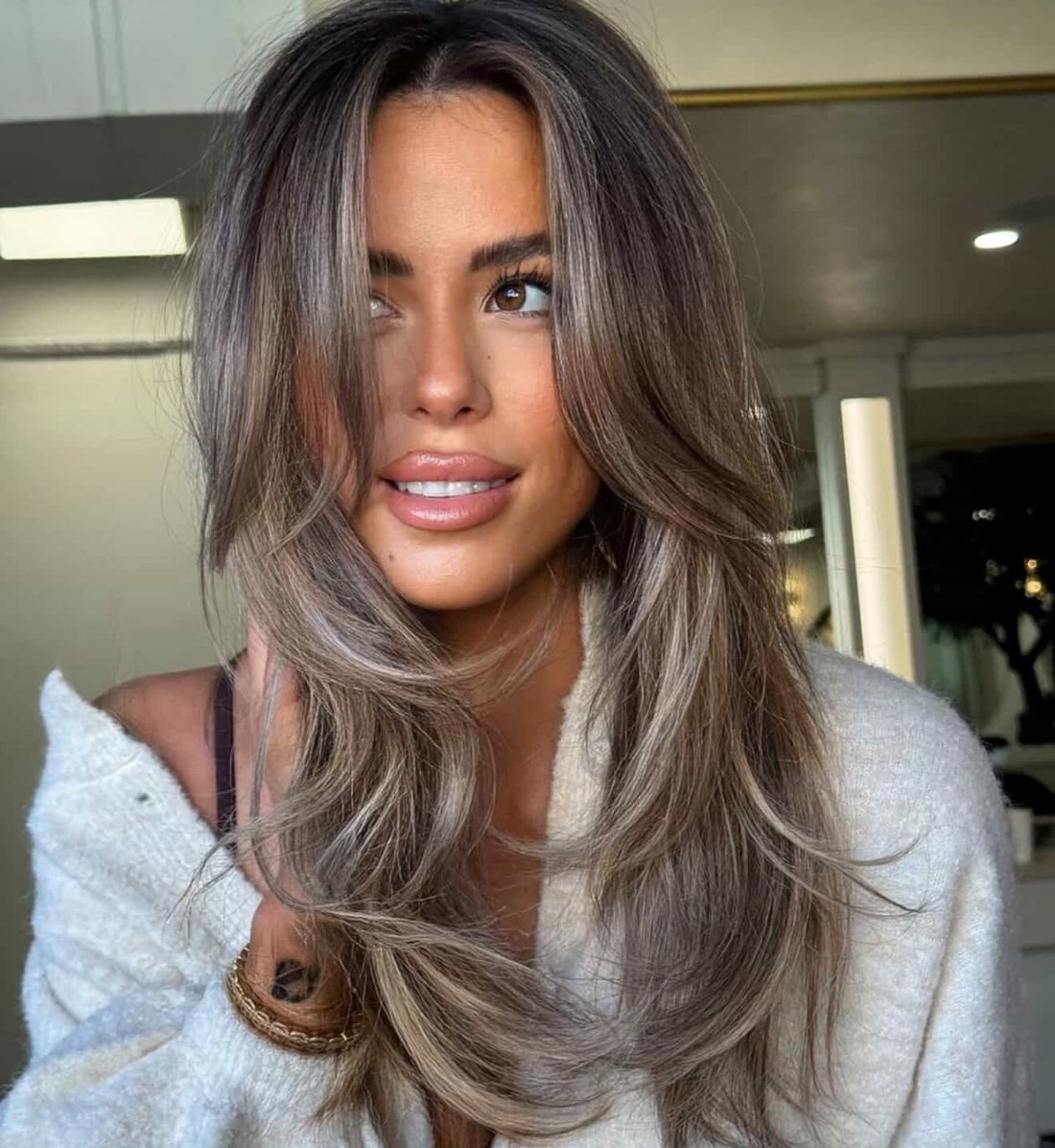 Long layered hair with soft ash-brown balayage and face-framing pieces